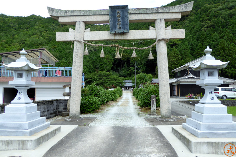 加都良神社を正面より望む。集落の一番奥にある、周囲の道は狭小なので注意されたし。鳥居をくぐると未舗装の参道が続き思出川に橋が架かっている。