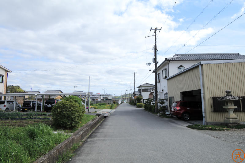 同じ場所から振り返って参道を望む（南）。130メートルほど向こうに一の鳥居が見える、周囲は田畑と住宅。