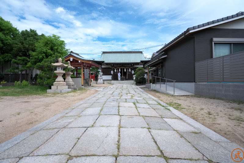 注連柱をくぐると拝殿前の石畳。社域は広くはないが建物がたくさんある。