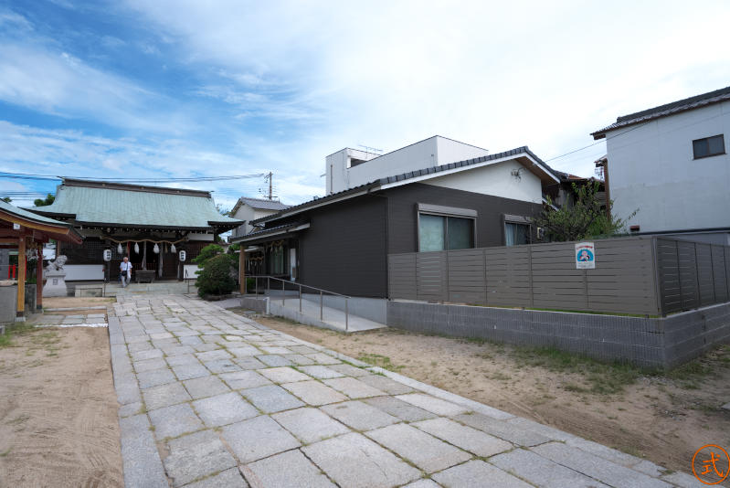 右手には真新しい集会所のような建物、奥に社務所がある。