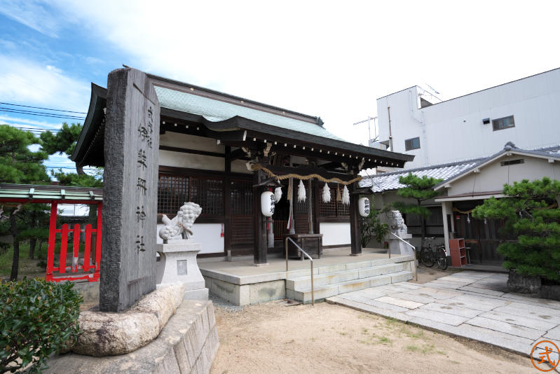 石標越しに拝殿を左側より望む。拝殿右手に社務所が見える。