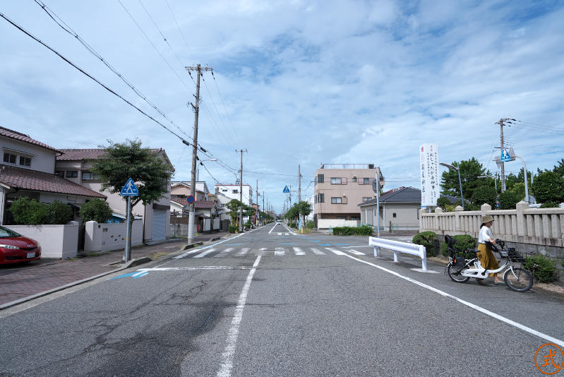 左側（西）を望む。垣の角にある神社の看板を右へ行くと500メートルほどで国道2号線になる。